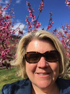 Cynthia Chiles with peach tree blossoms
