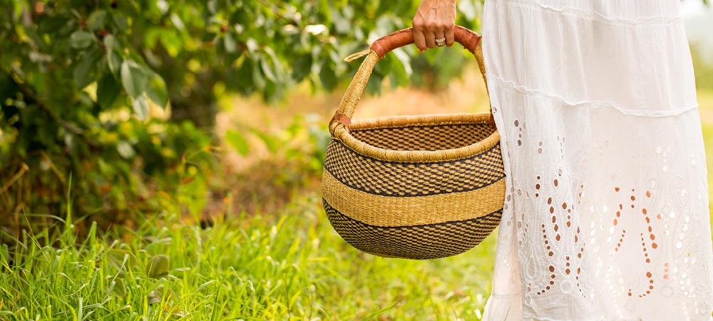 Woman holding basket in orchard