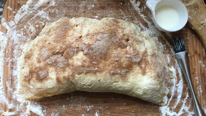 Large scone dough brushed with cinnamon sugar