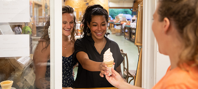 young women serves ice cream to excited women