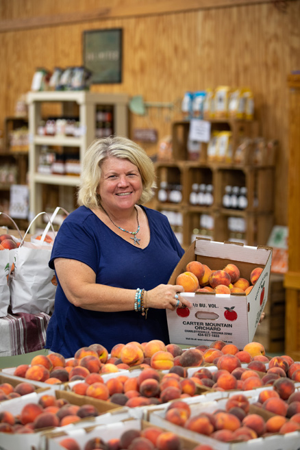 Cynthia Chiles holding crate of peaches