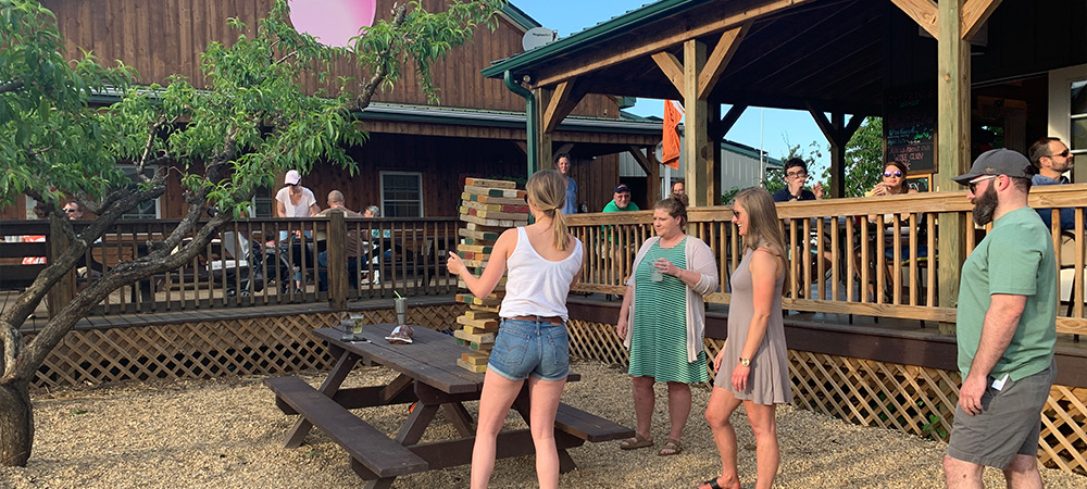 Visitors playing Giant Jenga and relaxing while listening to live music at Crozet's Orchard Jams