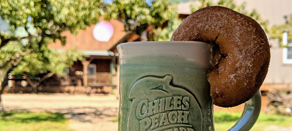 Chiles Peach Orchard mug of cider with cider donut