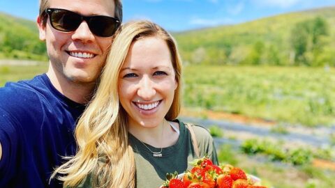 Couple with fresh picked strawberries and mountain view at Chiles Peach Orchard