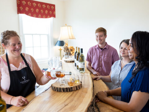 Small group smiling with wine tasting flight