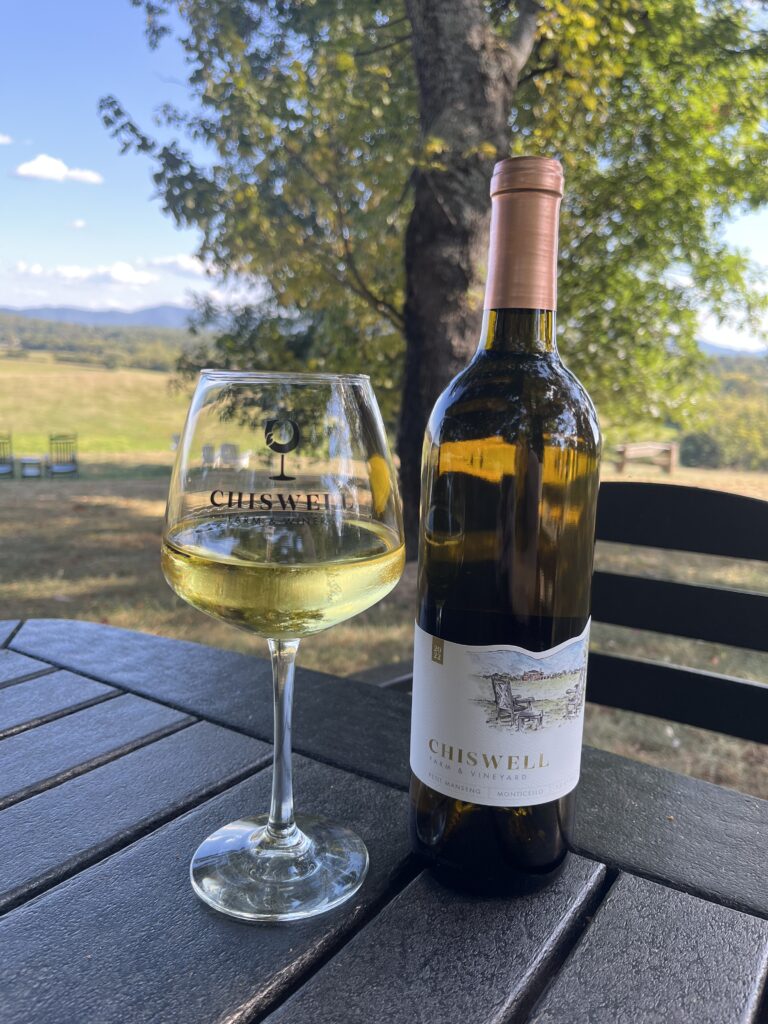 A glass and bottle of petit manseng wine