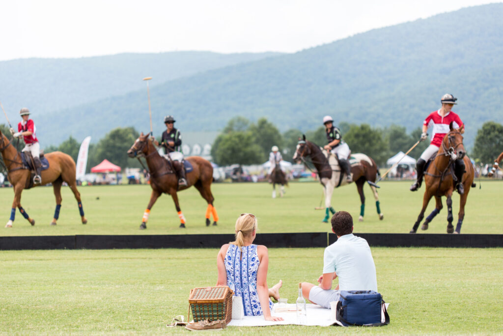 Two people having a picnic watching a polo match