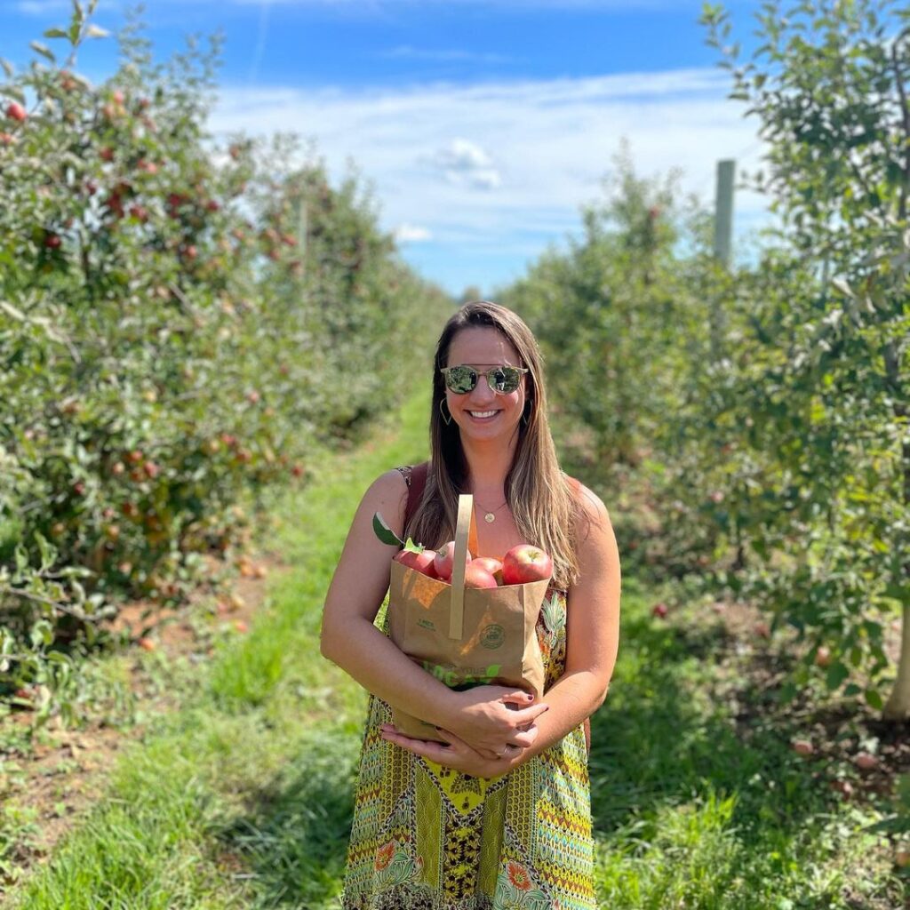 A woman with a bag of apples in an apple orchard at Chiles Peach Orchard