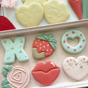 Valentine's Day sugar cookie designs, including lips, a rose, a strawberry, a heart, an X, and an O.