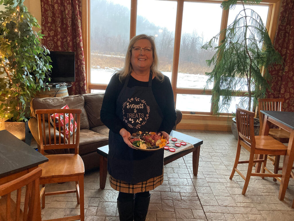 A woman holding a charcuterie board.