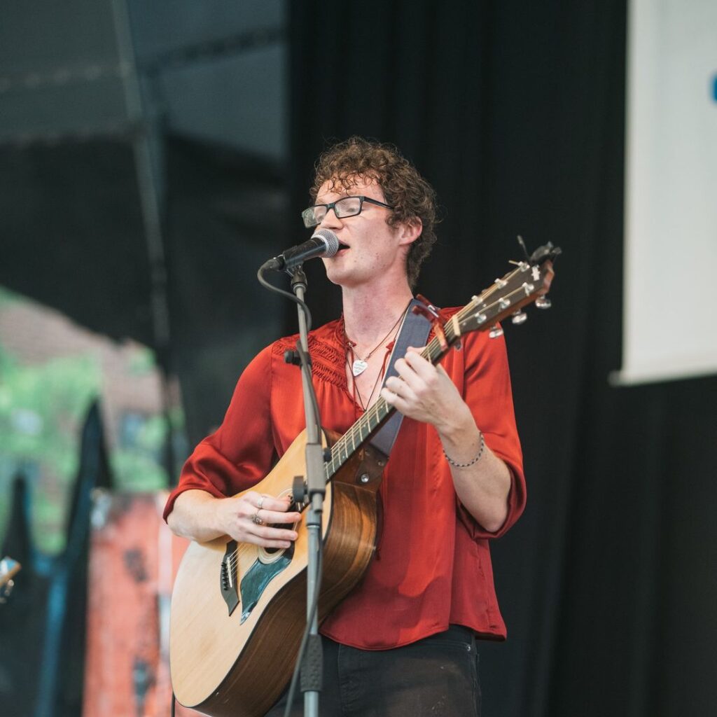 Musician Theocles playing guitar on stage