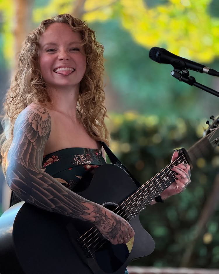 Guitarist Skylar Green performing outside.