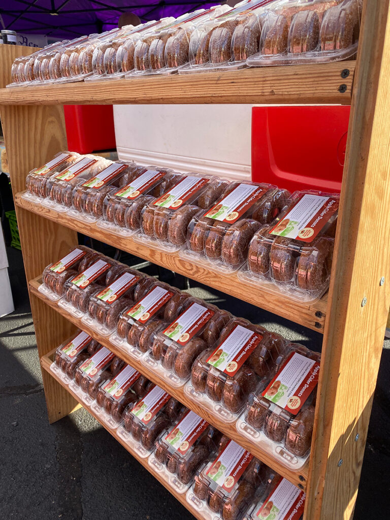 Apple cider donuts packaged on shelves.