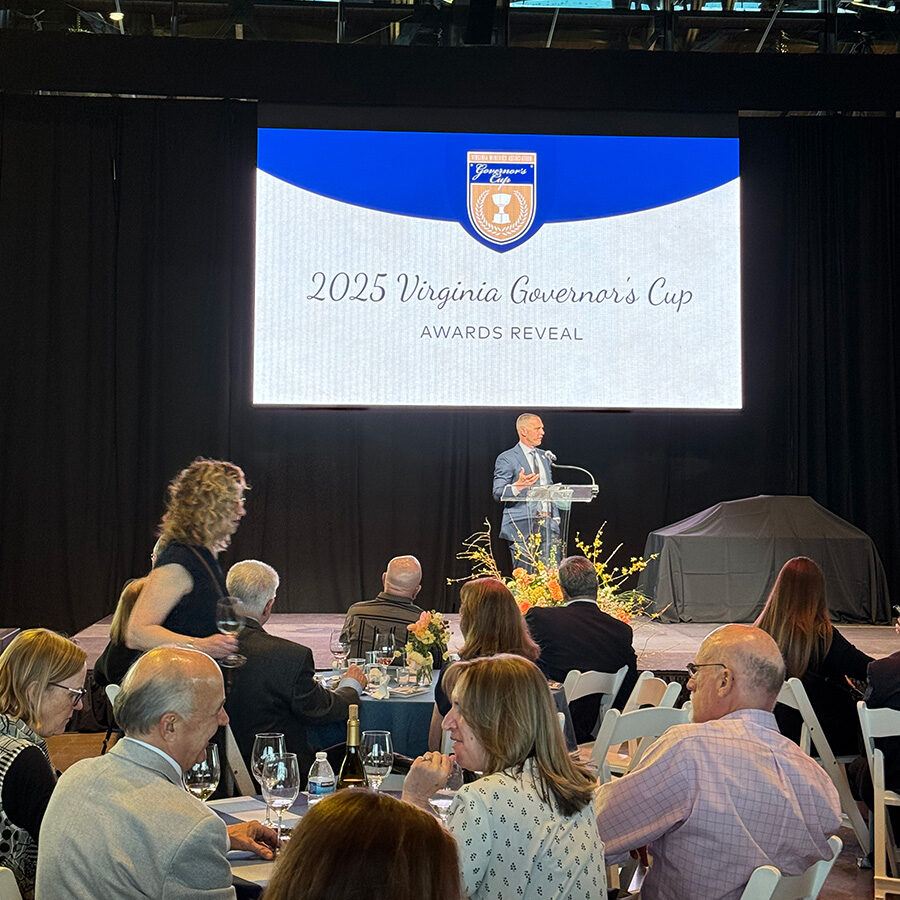 A speaker in front of a screen at the 2025 VA Governor's Cup Gala