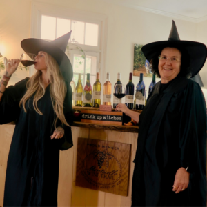 two women dressed as witches drinking wine