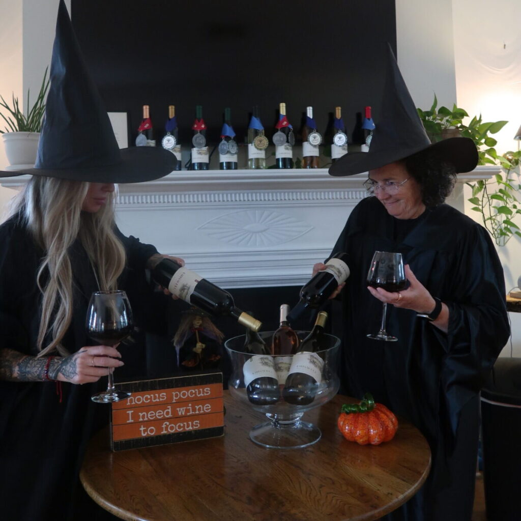 two women dressed as witches over a cauldron of wine
