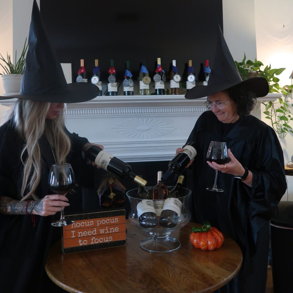 two women dressed as witches over a cauldron of wine