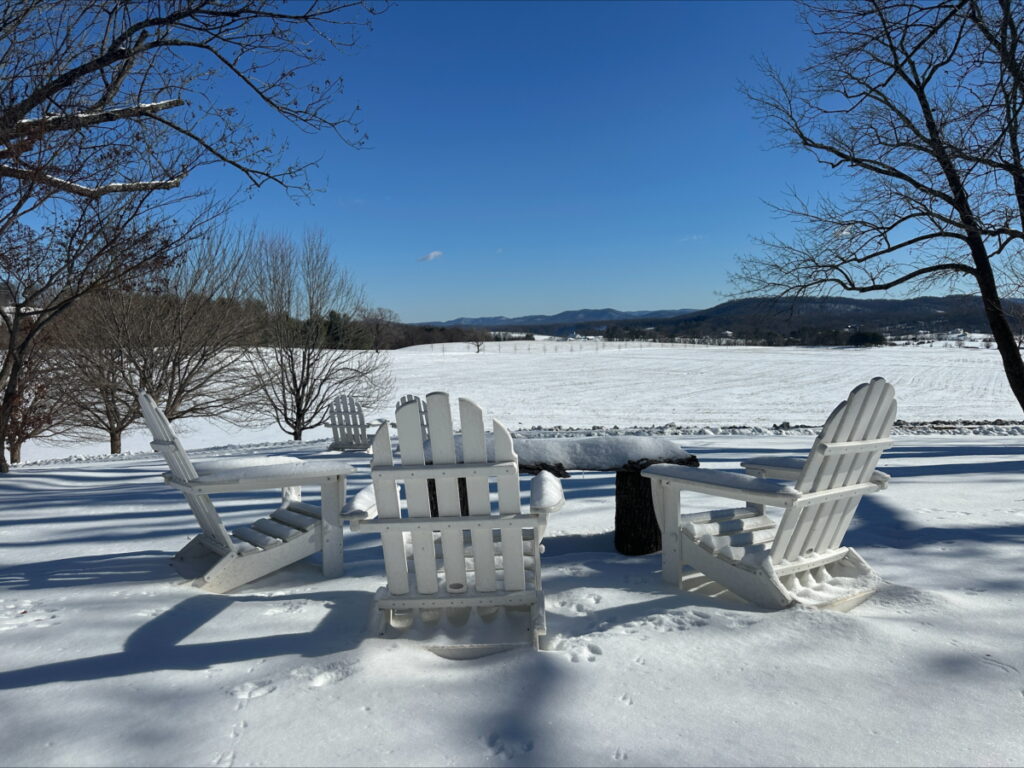 Adirondak chairs on a snowy field