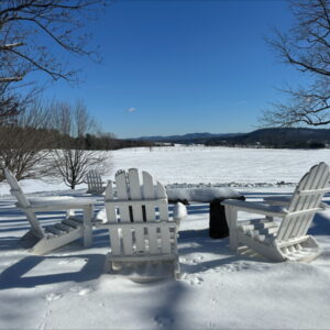 Adirondak chairs on a snowy field
