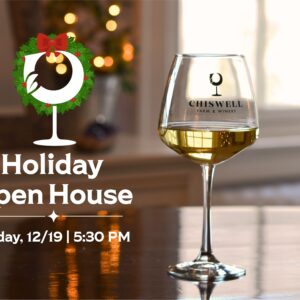 A glass of white wine on a table with lights in the background and a graphic reading "Holiday Open House"