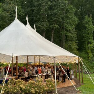 Guests at an event under a large outdoor pavillion.