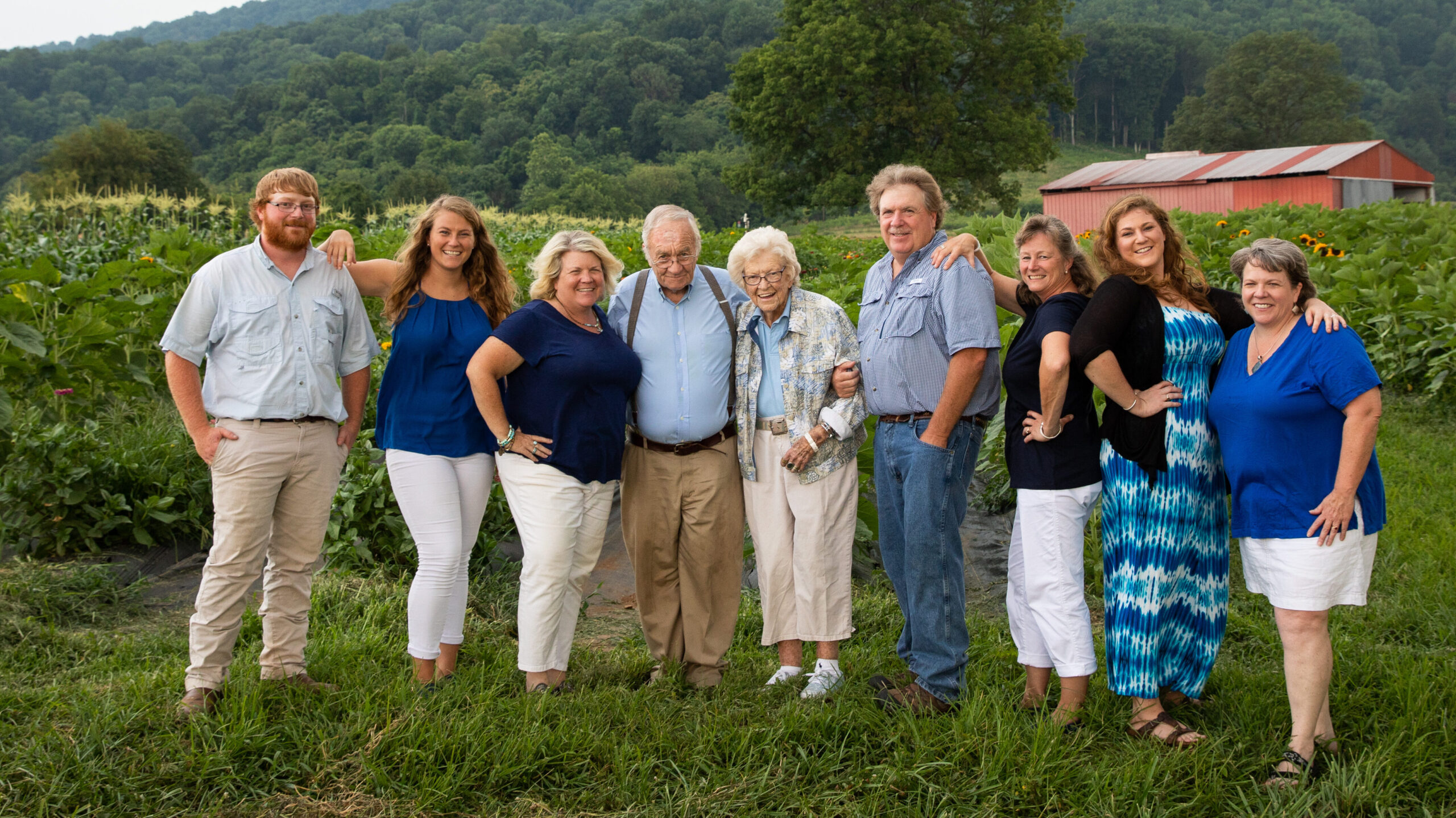A multi-generational farming family posing in a field.