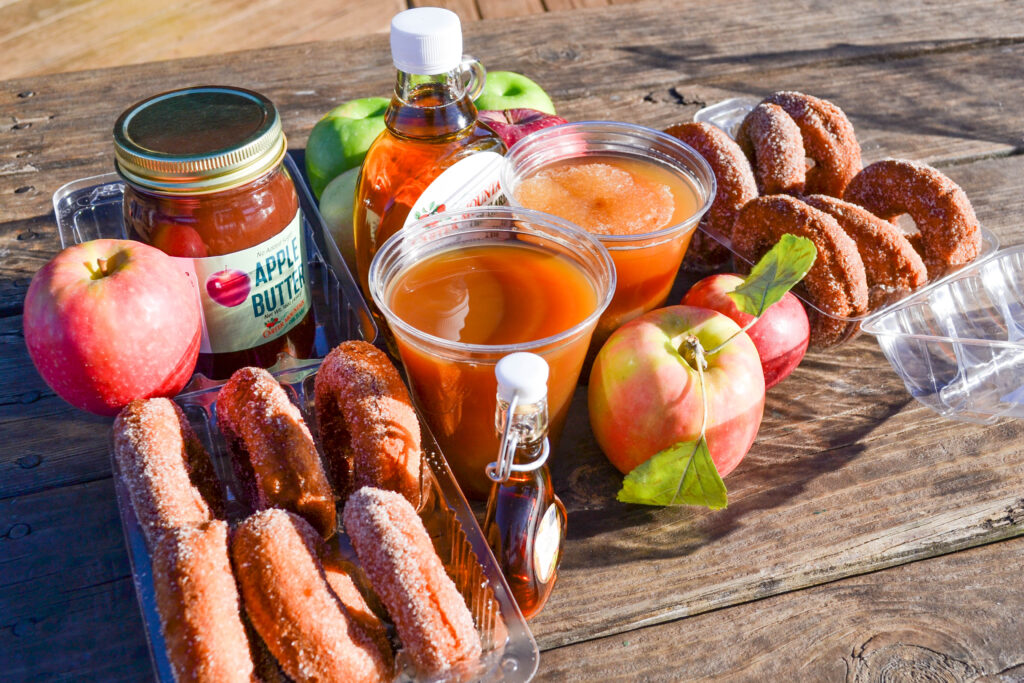 apple cider donuts, apple cider slushies apple butter laid out on table