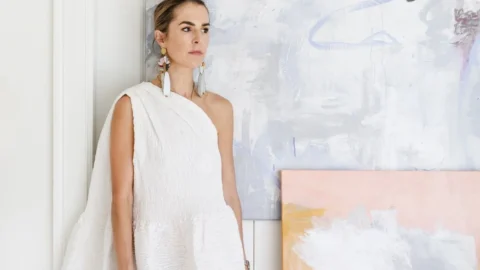 artist standing with art behind her