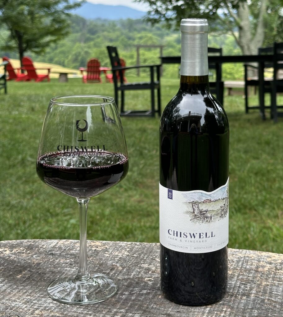 A glass and bottle of red wine outside