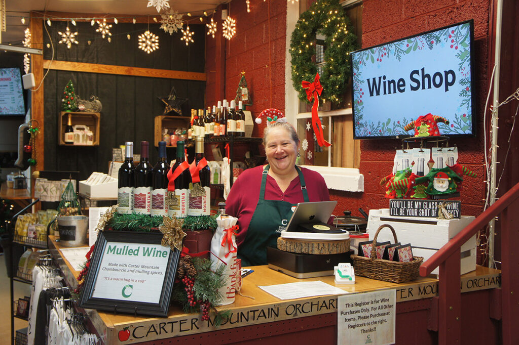 A holiday-themed wine shop register with a friendly employee.