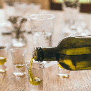 olive oil being poured into small tasting glasses.