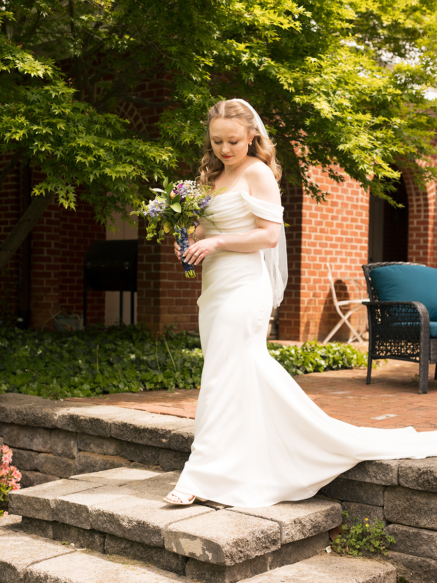 A bride outside stepping down stone steps