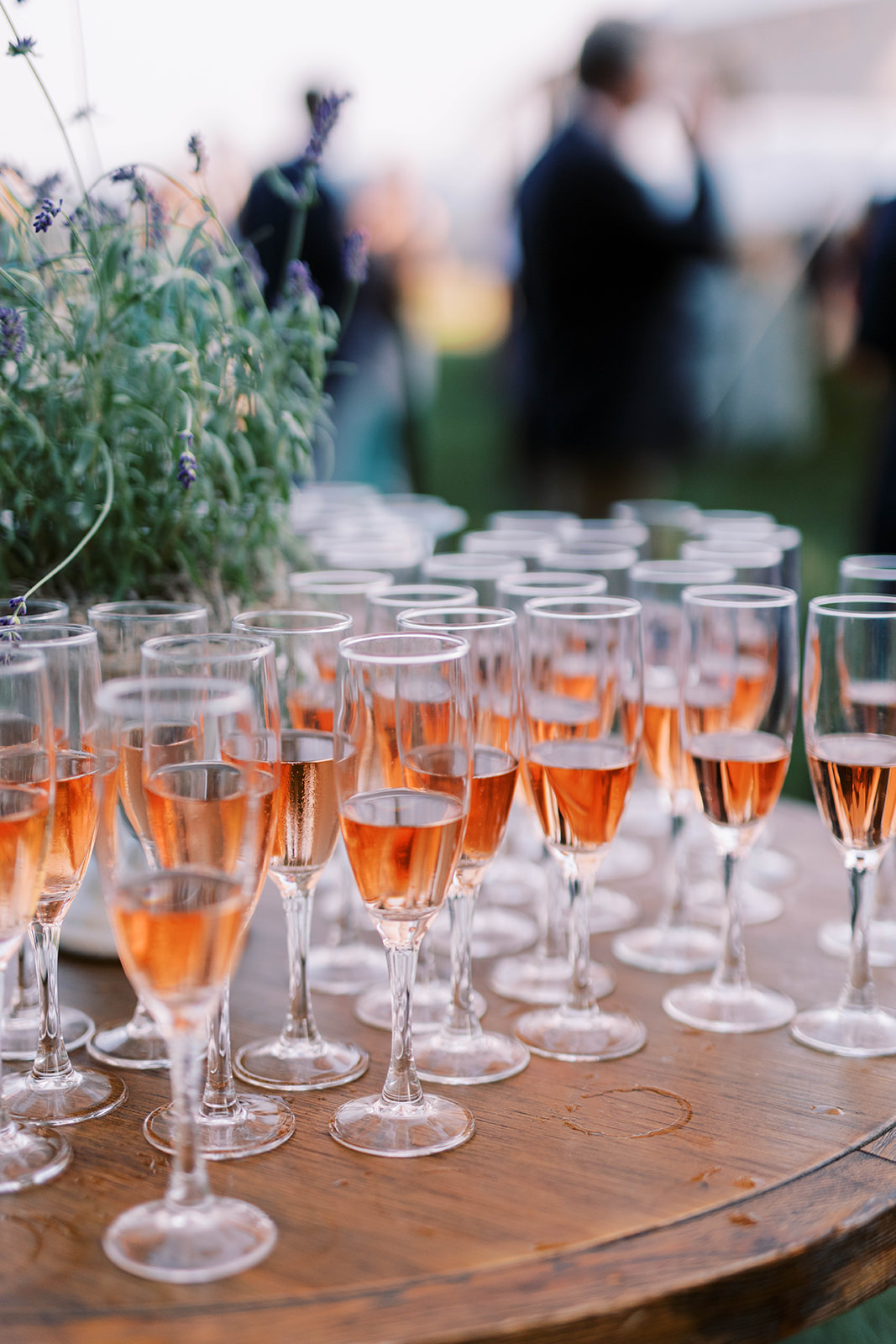 Champagne flutes on a table outdoors filled with sparkling rosé