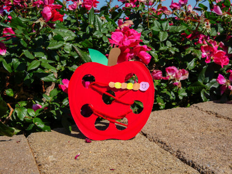 A papercraft apple with holes and lacing