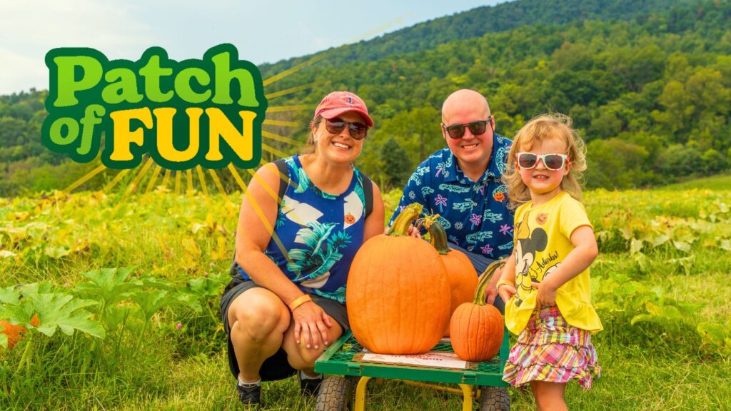 A family with a cart full of pumpkins in a pumpkin patch