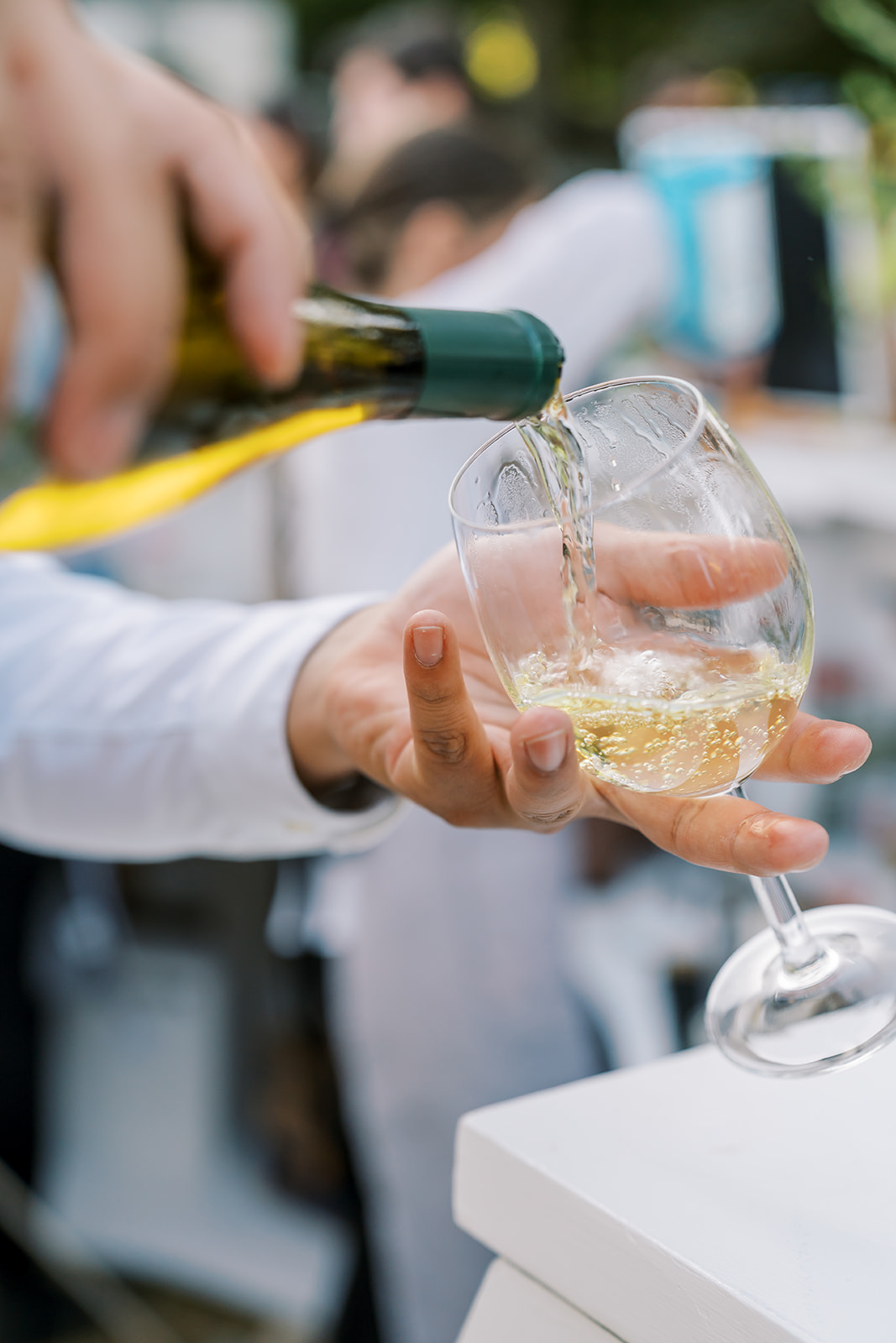 A glass of white wine being poured at an angle