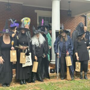 A group of women dressed as witches outdoors on a porch