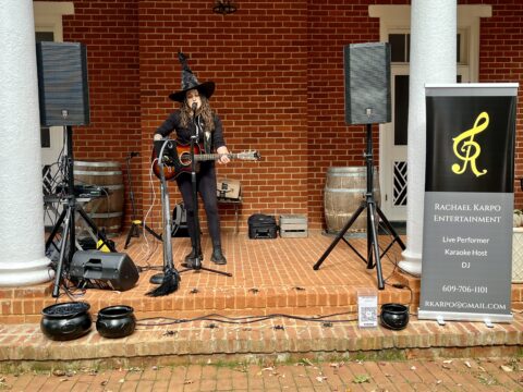 Rachael Karpo playing guitar while dressed as a witch