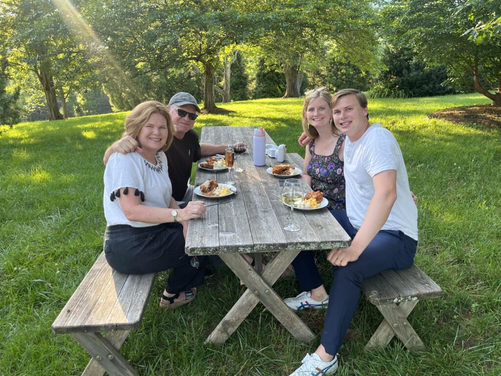A group of people enjoying a picnic and wine outdoors