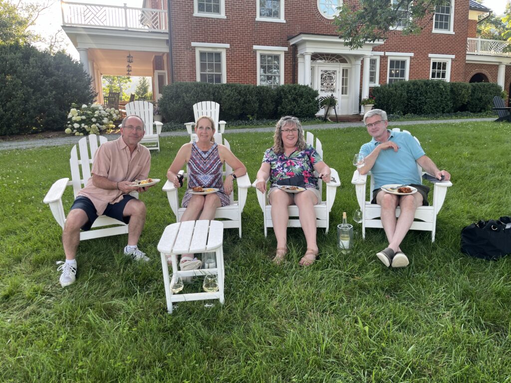 A group of people enjoying a picnic and wine outdoors