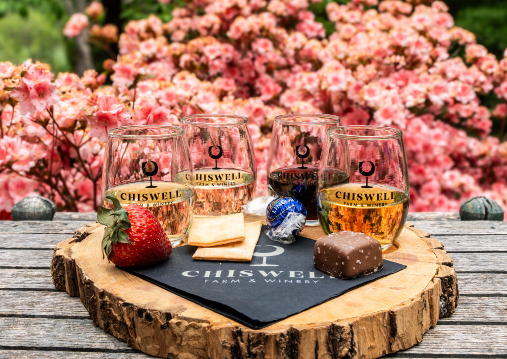 A wine flight featuring four glasses of wine and four snack pairings.
