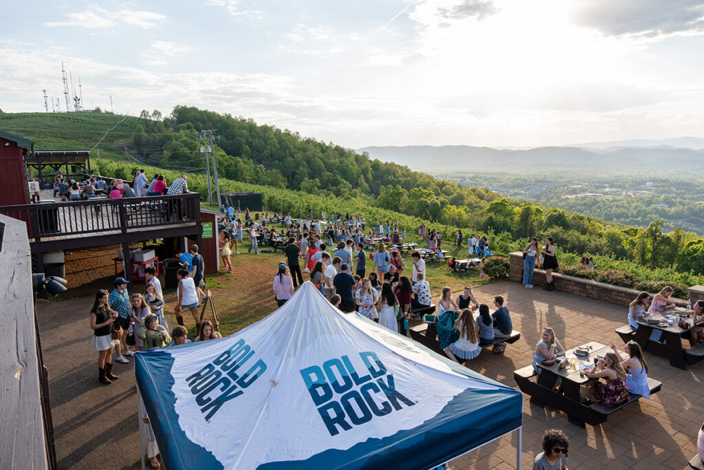 A crowd on a mountainside at sunset