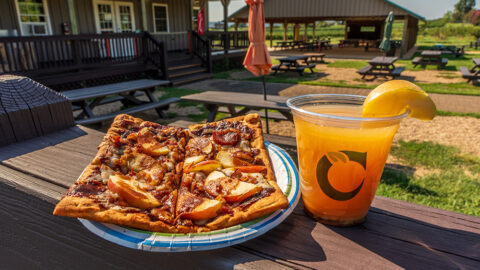 A square bbq apple pizza with an orange cider drink